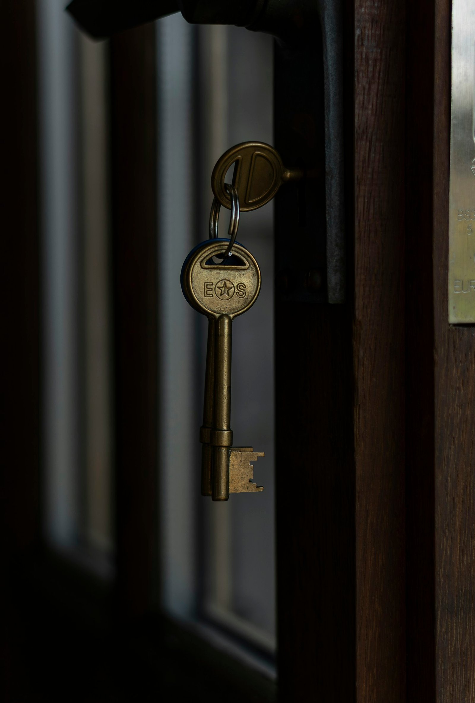 Brass keys hanging from a door lock